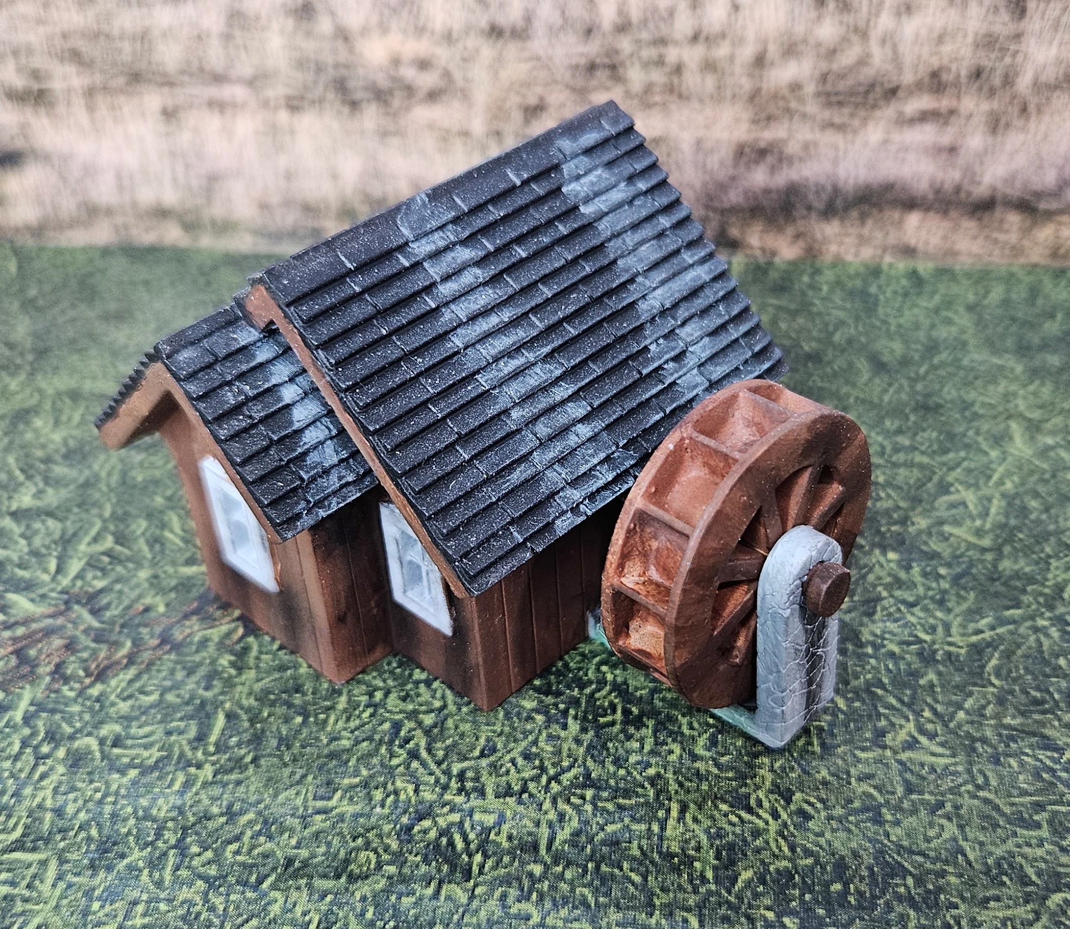 Angled view of HO scale waterwheel with small building